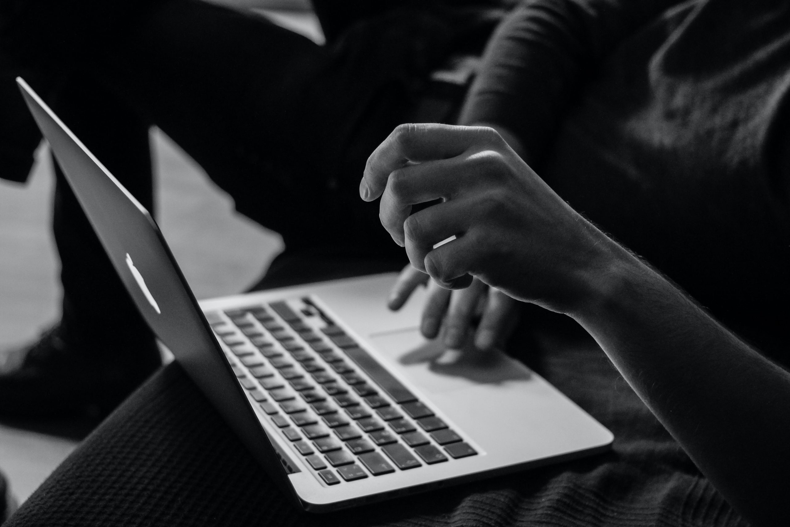 laptop on lap black and white image